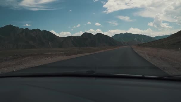 Route dans les montagnes tiré à travers le pare-brise de la voiture — Video