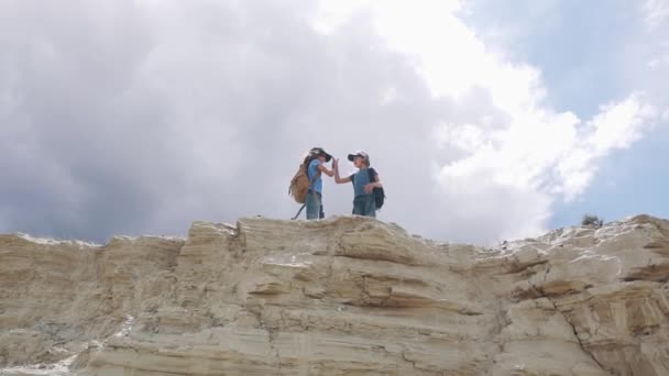 Діти мандрівники з рюкзаками дають один одному високі п'ять — стокове відео