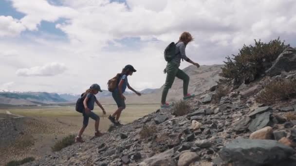 Мать и двое детей отправились в поход в горы. группа путешественников в горах. семейные путешественники в горах . — стоковое видео