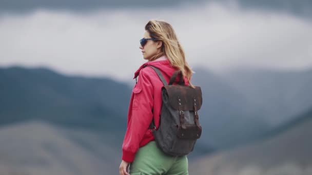 Πορτρέτο ενός τουριστικού νεαρή γυναίκα με ένα σακίδιο. πίσω όψη — Αρχείο Βίντεο