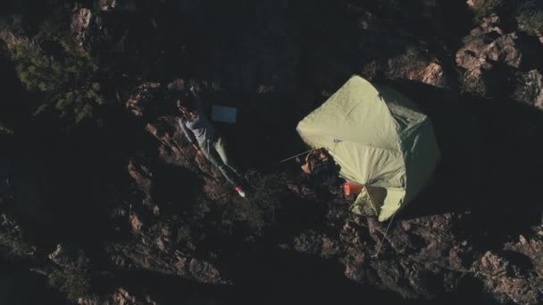 Turysta dziewczyna leżącego w pobliżu namiotu w górach. jedność z naturą i spokój — Wideo stockowe