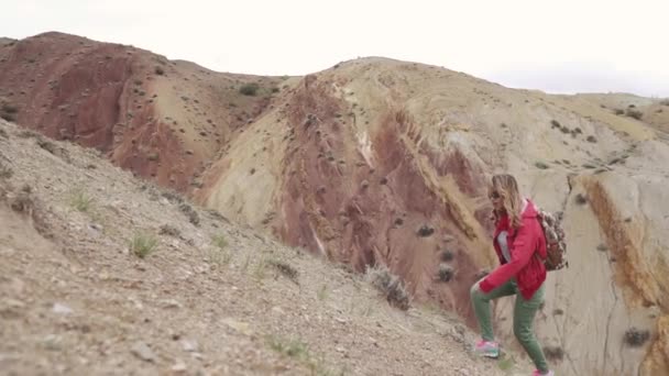 戴墨镜的女孩在一个不寻常的地形上旅行 红色山和红色地球象在火星上 — 图库视频影像