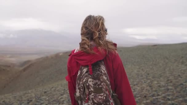 Портрет путешественника в горах под проливным дождем. туристка одна с рюкзаком в горах — стоковое видео