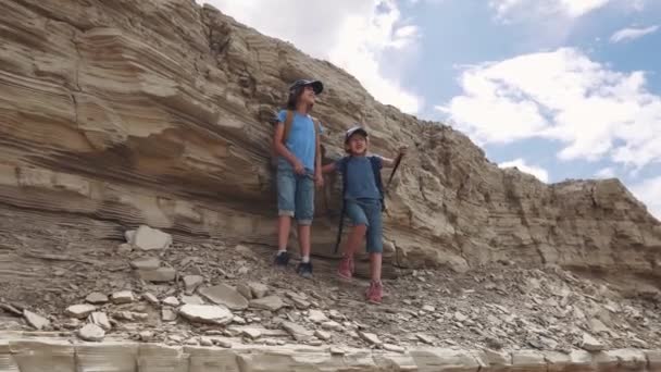 Τα παιδιά του ταξιδιώτες στέκεται στον απότομο βράχο και θαυμάστε τη θέα. — Αρχείο Βίντεο