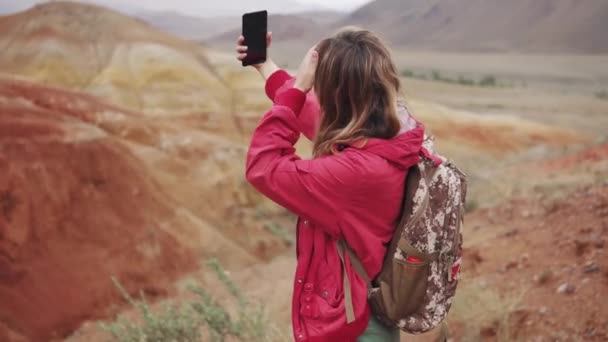 Τουριστική κορίτσι κάνει selfie στο smartphone κάμερα. κόκκινα βουνά και κόκκινη γη ως στον Άρη. — Αρχείο Βίντεο