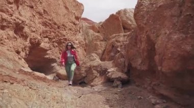 turist dağlık arazi yürüyor. Genç kadın yolcunun sırt çantası ile. kızıl toprağı ve dağlar, Mars'ta gibi
