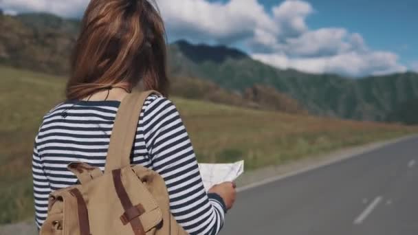 バックパック旅行者の女性の肖像画。背面図。高速道路の上を歩いて女の子の観光 — ストック動画