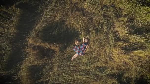 Aerea. una giovane donna in un abito luminoso sdraiata nel fienile. Il concetto di unità con la natura e la tranquillità. vista dall'alto . — Video Stock