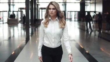 Genç iş kadını bir modern iş merkezindeki portresi. iş takım elbiseli bir kız bir ofis binası lobiye gider