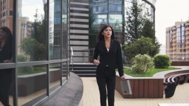 Bir iş merkezi zemin karşı yürüyen emin iş kadın portresi. kağıtlar için evrak çantalı iş takım elbiseli kız