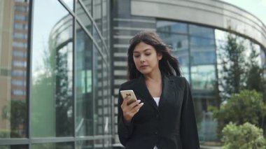 iş kadını, bir cep telefonu için bir ileti yazdırır. iş giysileri içinde bir kadın portresi