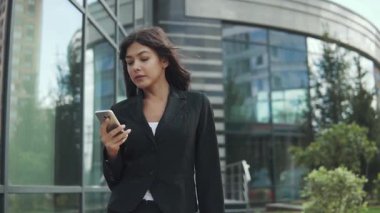 çekici kadın bir smartphone bir modern iş merkezi arka plan üzerinde kullanır.