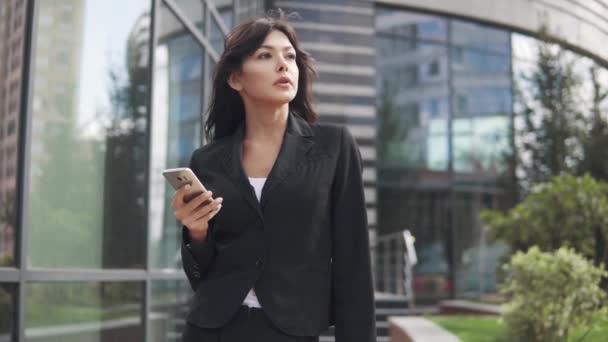 Krásná mladá žena v obleku pomocí chytrého telefonu. obchodní žena SMS zprávu na mobilní telefon — Stock video