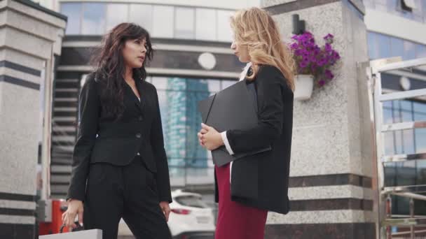 Reunión de socios de negocios al aire libre. dos mujeres de negocios en trajes estrictos están hablando — Vídeo de stock