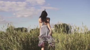 neşeli ve mutlu uzun otların ile araziyi kaçan kız. ağır çekim