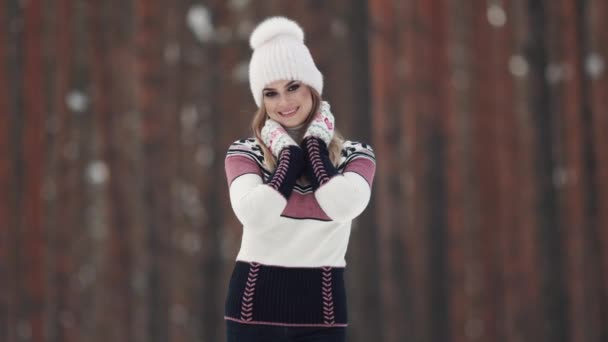 Retrato de uma linda e encantadora menina em um fundo escuro. Jovem mulher na floresta de inverno contra o pano de fundo de uma floresta de pinheiros — Vídeo de Stock