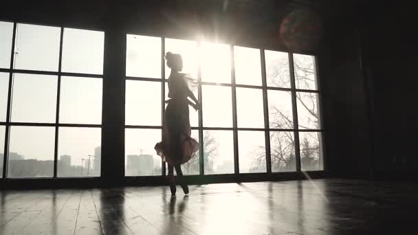 Silhouette graciösa graciösa ballerinor mot bakgrund av solen strålar. balettdansös dansas på tiptoes i pointe skor. slowmotion — Stockvideo