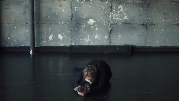 Manliga gymnast gör stretching sitter på golvet — Stockvideo