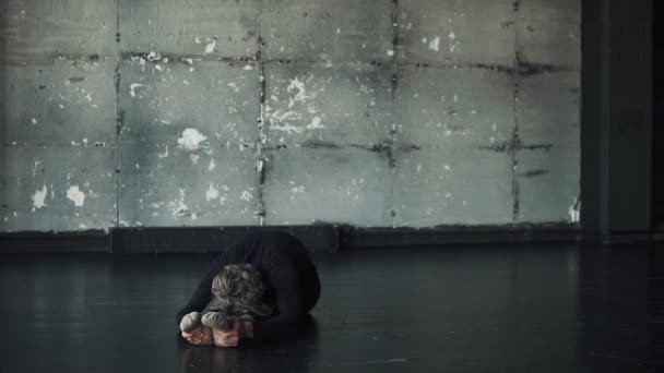 Junger Mann macht Yoga auf dunklem Hintergrund — Stockvideo