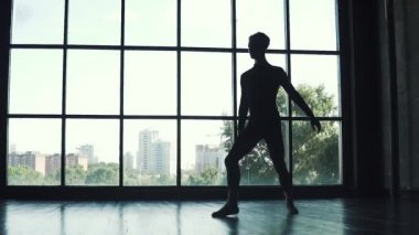 bir bale dansçı erkek silüeti. Genç adam büyük bir pencere arka plan üzerinde klasik bale. ağır çekim