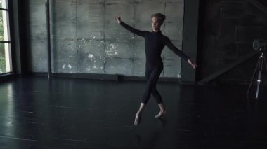 balet yüksek atlama ve tek ayak üzerinde dönüş yapar. karanlık bir arka plan stüdyoda dans genç adam. ağır çekim