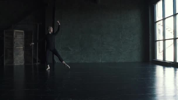 Балетный танцор в студии. Молодой человек совершает прыжок в высоту и красиво танцует на темном фоне. замедленное движение — стоковое видео