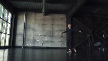 erkek dansçı sessizce Studio karanlık bir arka plan üzerinde dönüyor. ağır çekim