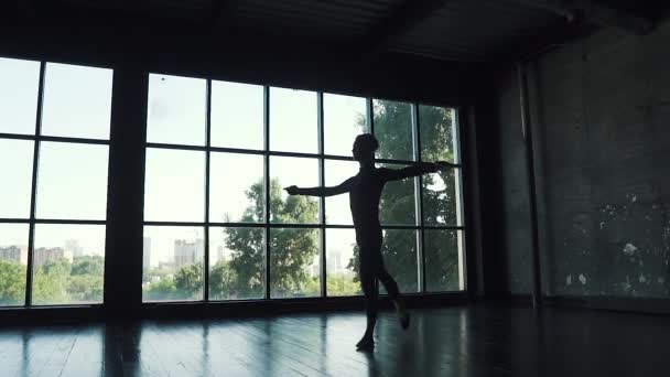 大きな窓の背景に男性ダンサーのシルエット。スローモーション — ストック動画