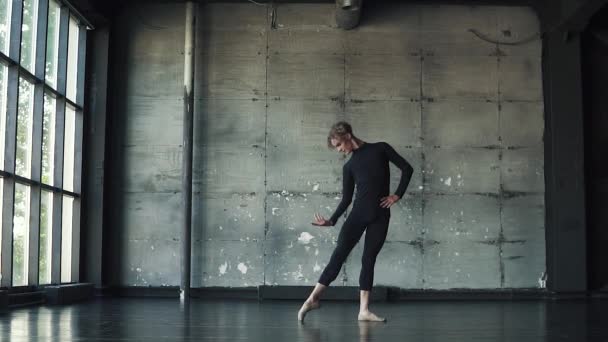 Ritratto di un ballerino di balletto su sfondo scuro. il ballerino gira in punta di piedi e si muove magnificamente. rallentatore — Video Stock