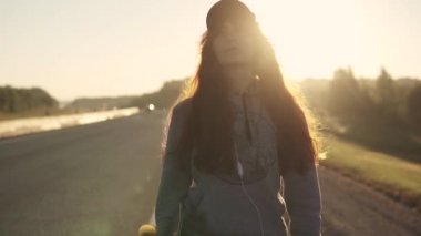 yakın çekim portre delici bir onun burun ve dudak ve kulaklık ile Kızıl saçlı bir kız. Sunset Bulvarında. ağır çekim