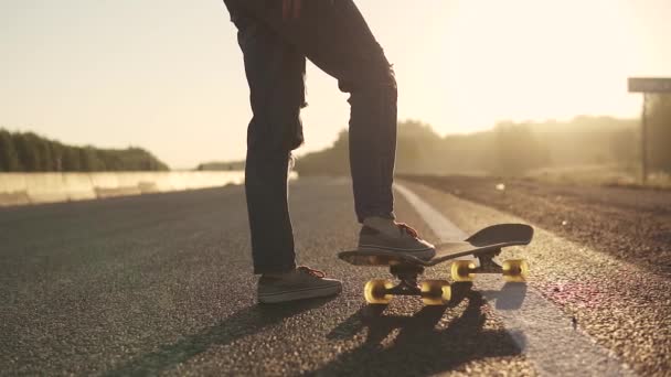 Närbild på skateboard i benen flicka vid solnedgången — Stockvideo