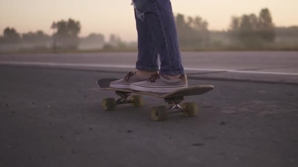 Close-up van de vrouwelijke benen. Meisje skateboarden op zonsondergang slow motion. — Stockvideo