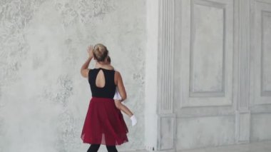 Genç kadın kollarında küçük bir bebekle vals