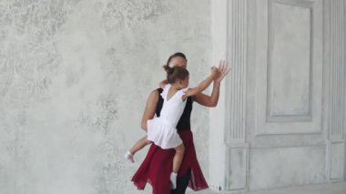 Genç bir kadın onun kollarında küçük bir çocukla dans ve gülümseyen