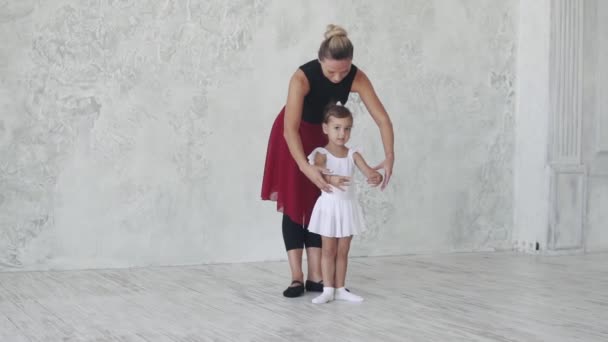 Coreógrafa enseña a una niña bailarina en una clase de ballet. Un profesor y un pequeño estudiante en una clase de ballet — Vídeos de Stock