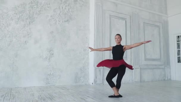 Giovane ragazza attraente sta ballando su uno sfondo leggero in studio. rallentatore — Video Stock