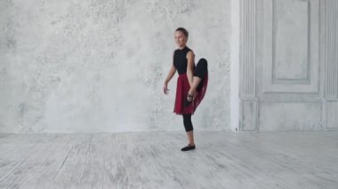 hafif bir arka plan üzerinde siyah bodysuits ve kırmızı etek balet. Balerin incelikle ve zarif taşır. ağır çekim