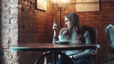 bir kafede güzel bir kız portresi. kız selfie fotoğraf makinesinde smartphone ve içecekler kahve yapıyor.