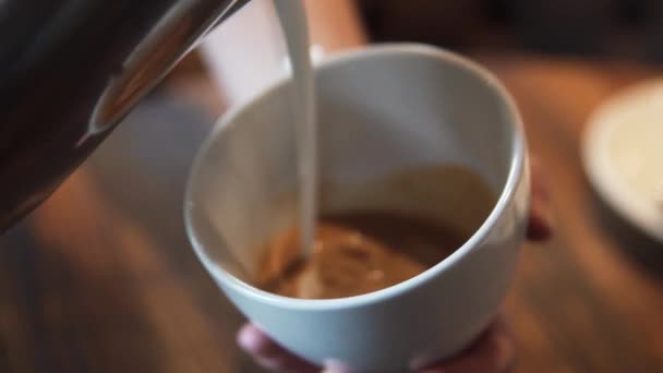 Waiter pours a latte or cappuccino into a glass — Stock Video
