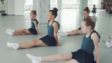 çocuk dans dersi. küçük kızlar yere otur ve öğretmen arkasında hareketleri tekrar