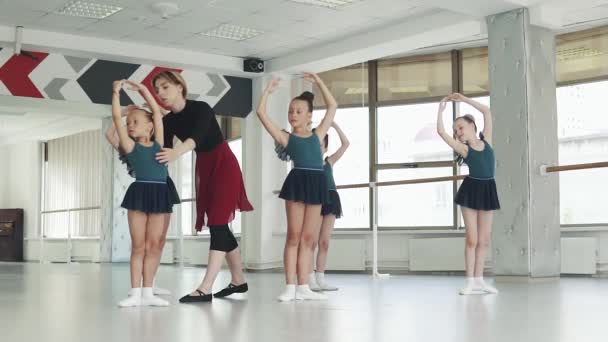 Insegnante di danza raddrizza piccola ballerina. bambini in classe di balletto in classe di balletto — Video Stock