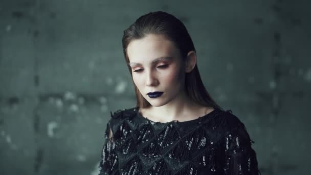 Retrato de una chica con maquillaje brillante y labios azules sobre un fondo oscuro. mujer joven con apariencia inusual — Vídeos de Stock