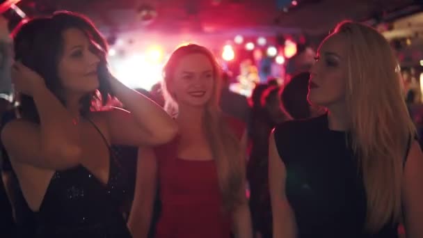 Vriendinnen in een menigte van mensen in een disco dansen — Stockvideo