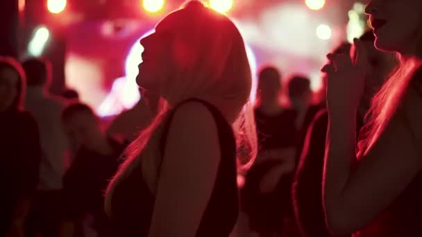 Jovencita bailando sexualmente en una fiesta en los rayos de los focos rojos — Vídeo de stock