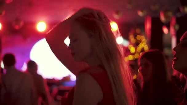 Портрет молодой женщины, танцующей на вечеринке среди толпы людей — стоковое видео