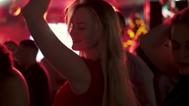 Portrait d'une jeune femme dansant à une fête au milieu d'une foule de personnes — Video