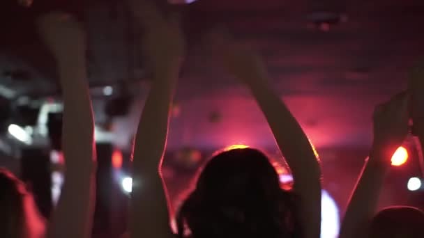 Силует дівчат, що танцюють у дискотеці. жінки махають піднятими руками . — стокове відео