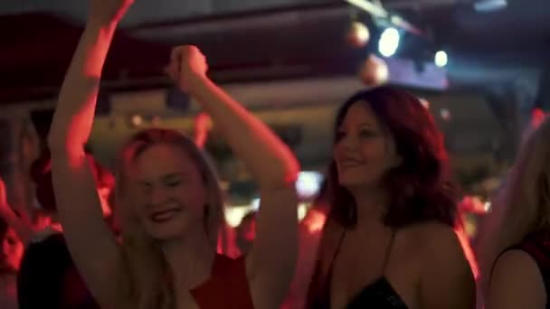 Fiesta en un club nocturno. una multitud de bailarines. chicas se están divirtiendo y sonriendo — Vídeo de stock