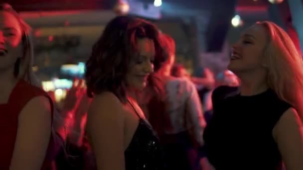 Party in einem Nachtclub. eine Menge tanzender Menschen. Mädchen haben Spaß und lächeln — Stockvideo