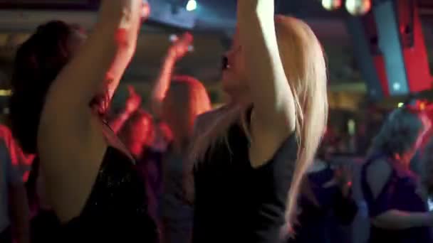 Φίλες χορό σε ένα πάρτι σε ένα πλήθος ανθρώπων. φίλους να διασκεδάσετε στη ντίσκο στο νυχτερινό κέντρο διασκέδασης — Αρχείο Βίντεο